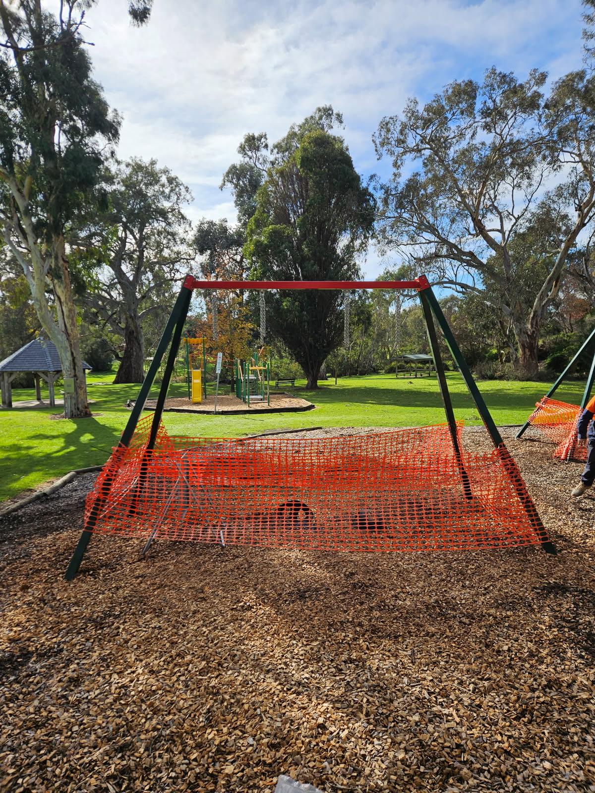 Swing set surrounded by orange bunting.