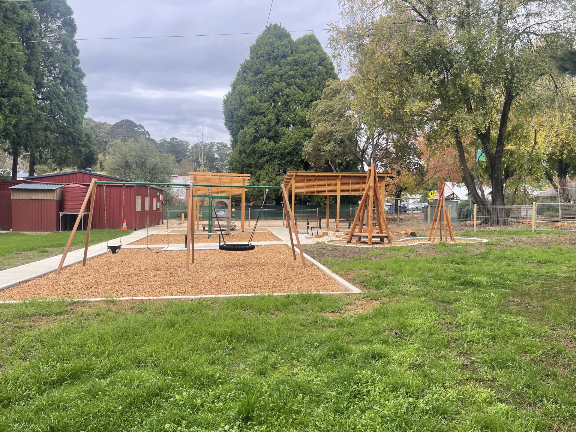 play equipment with bark chips and a concrete footpath