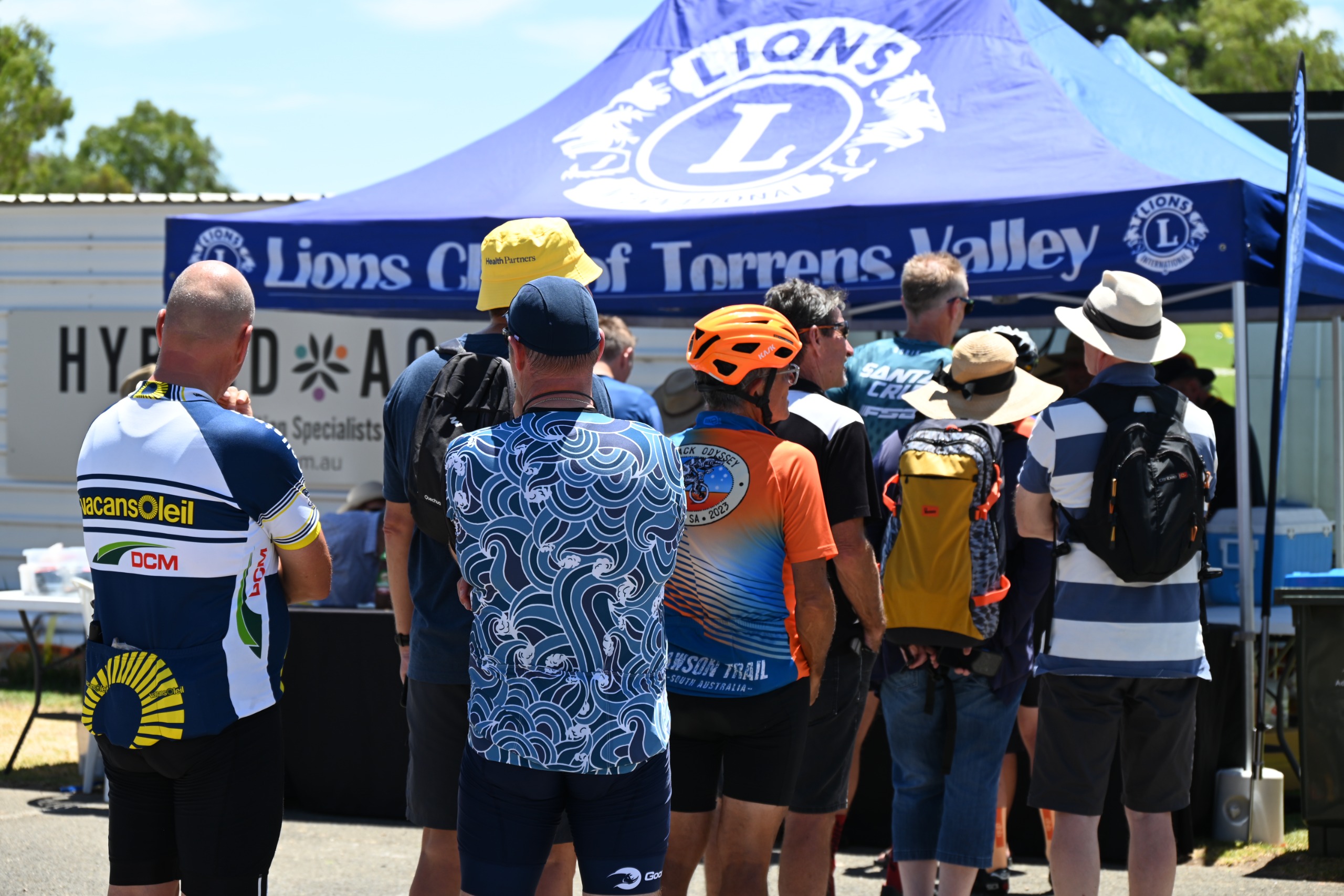 People lining up in front of a blue marquee